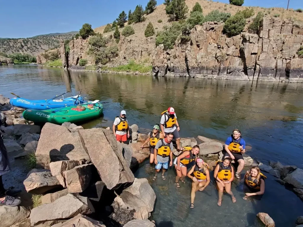 Team on a group rafting trip enjoying a quick soak in a hot spring.