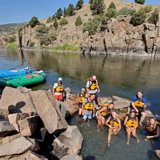 Team on a group rafting trip enjoying a quick soak in a hot spring.